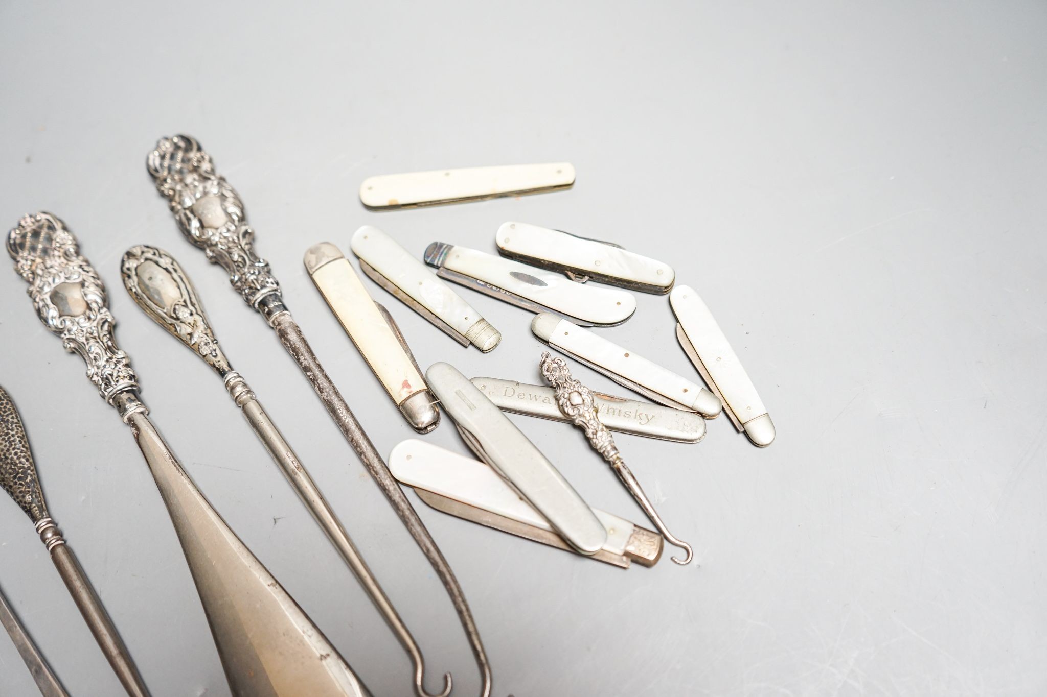 Eight various silver bladed fruit knives, three silver handled button hooks and silver handled shoe horn and button hook set